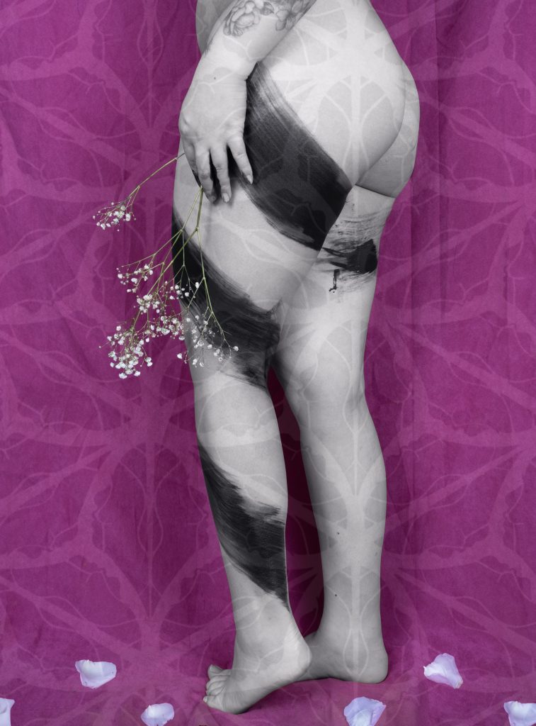 Image of the hips down, a nude female body with paint marks all over. She is holding flowers that drapes towards the floor