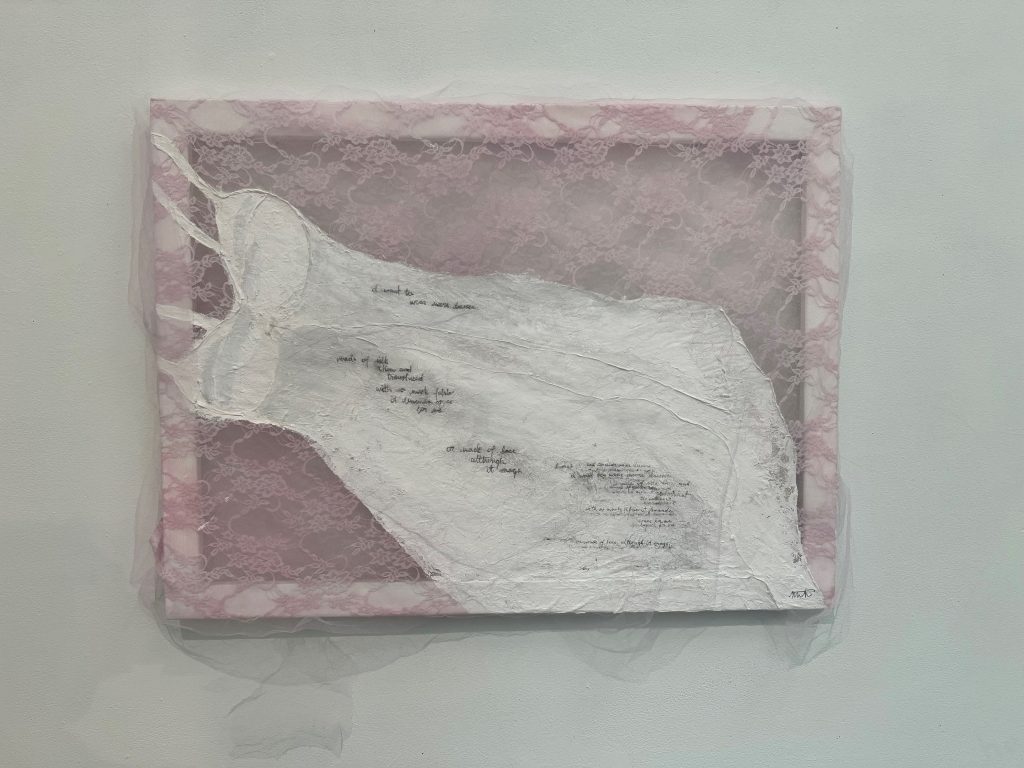 An image of "exposed", a canvas made of lace with lingerie painted on it, and a poem written in charcoal
