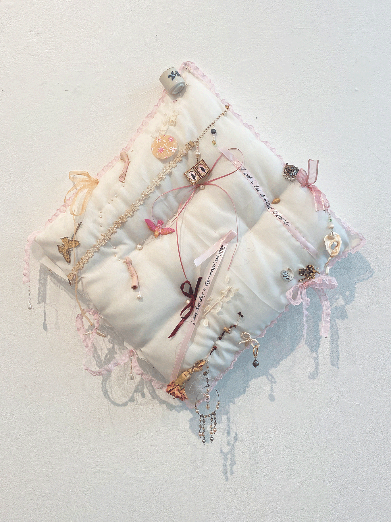 A pillow with various ornamental objects sewn onto. 
