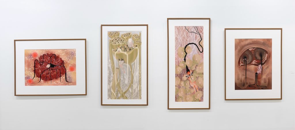 Installation view of four framed pieces mounted on a wall, each depicting an abstract/surrealist scene.